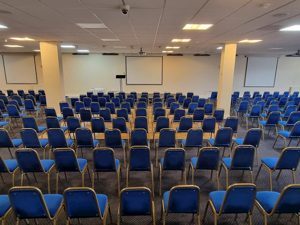 Conference room with blue chairs, ready for a professional event or presentation. - Banner