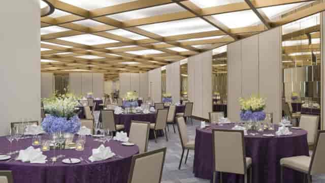 Elegant event space in Four Seasons Bengaluru with purple linens, perfect for corporate gatherings.