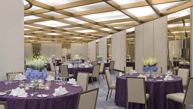 Elegant event space in Four Seasons Bengaluru with purple linens, perfect for corporate gatherings.