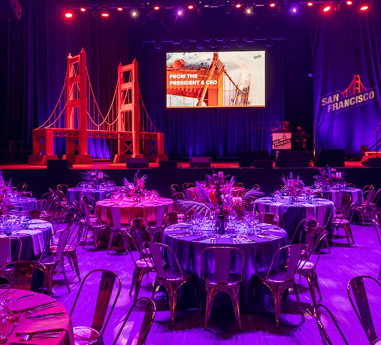 Lawn gala at North Island Amphitheatre with floral tables and Golden Gate backdrop.