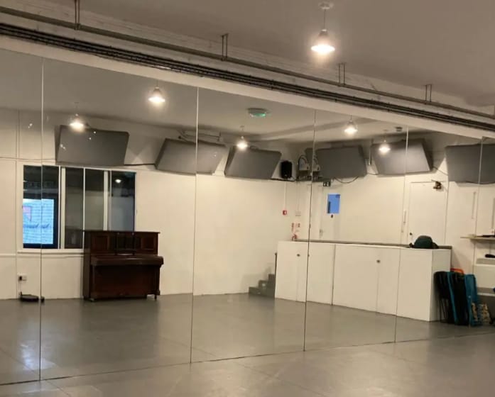 Versatile event space with mirrored walls, ideal for workshops and meetings.
