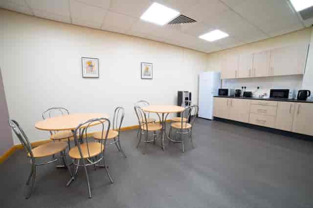 Blythe Room at Hollyfields Centre: round tables for meetings and events, calm decor.