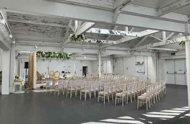 Versatile event space with elegant chairs for weddings and corporate events in bright ambiance.