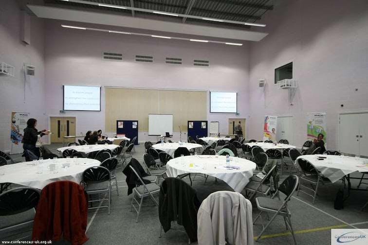 Conference Center event room with round tables, ideal for meetings and presentations.