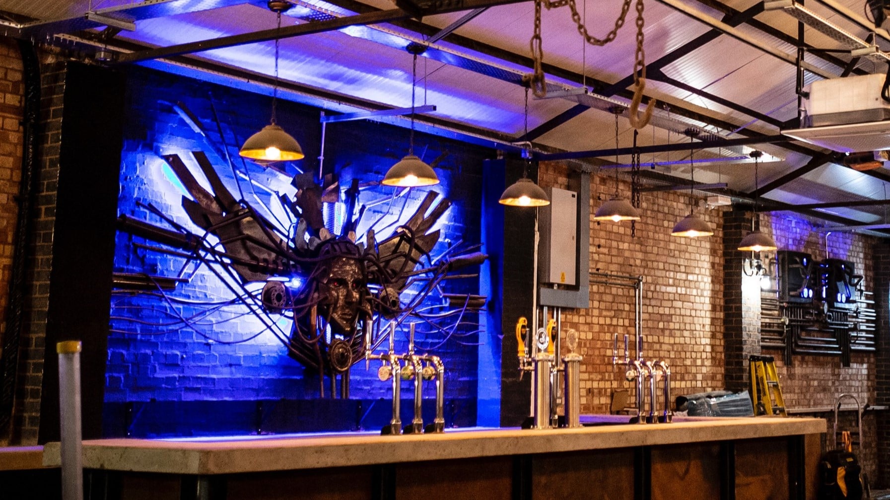 Stylish industrial bar with blue lighting, ideal for networking events and cocktail receptions. - Banner
