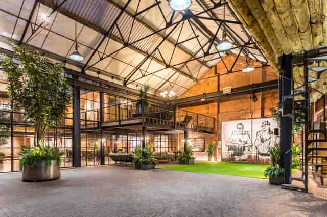 Industrial-chic breakout area with soaring ceilings, perfect for creative networking and events.