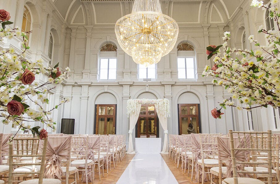 Elegant wedding venue at Grand Station with blush chairs and a stunning chandelier.