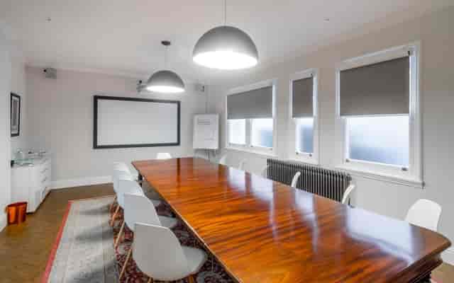 Modern meeting room with wooden table, ideal for collaborative brainstorming sessions.