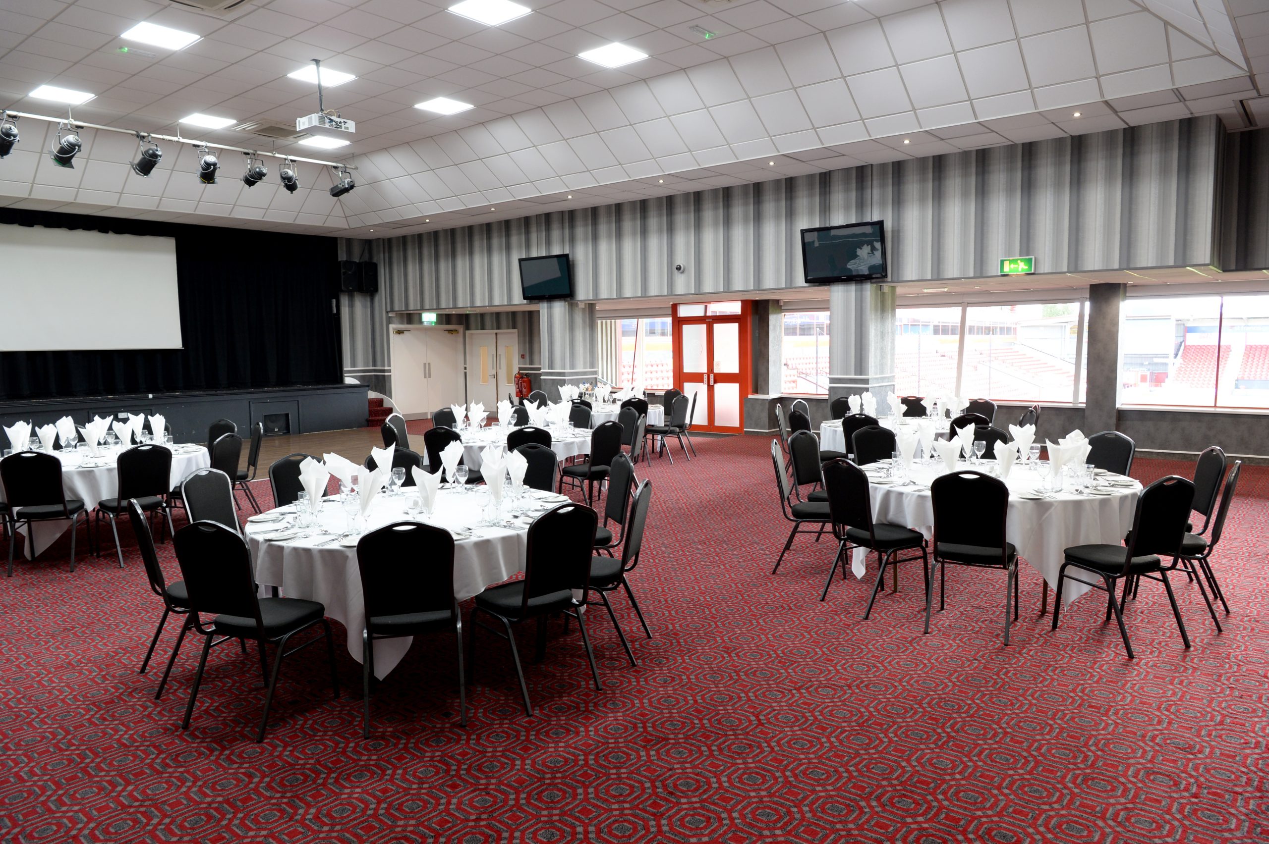 Function Room at The Dell Stadium with round tables, ideal for conferences and events. - Banner
