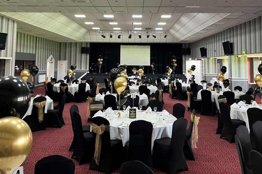 Elegant Albert McPherson Lounge set for formal corporate event with black and gold decor. - Banner
