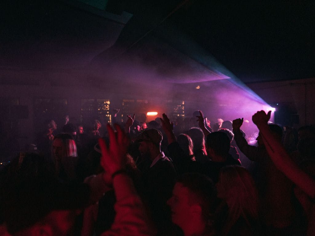 Vibrant warehouse event with dynamic lighting and engaged attendees for networking and celebration.