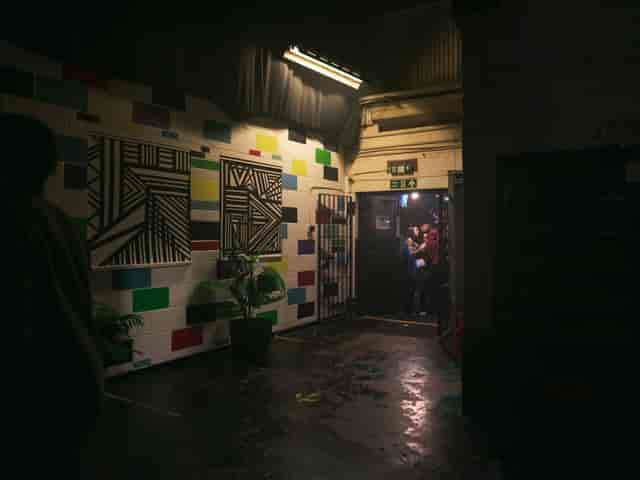 Vibrant corridor with colorful wall art in 7SVN warehouse for events and networking.