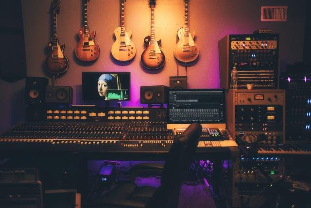 Recording studio with guitars and sound equipment for music events and workshops.