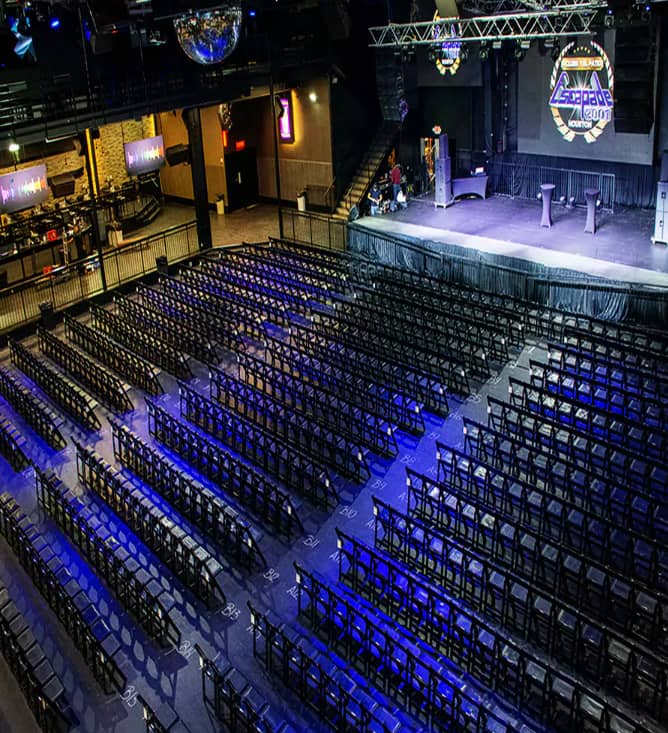 Escapade Event Centre setup with chairs and stage for presentations or performances.