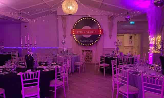 Christmas party setup with elegant tables and ambient lighting at Manor by the Lake.