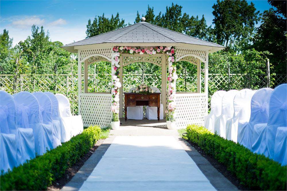Outdoor wedding gazebo with floral decor at Warwick House, ideal for romantic ceremonies.
