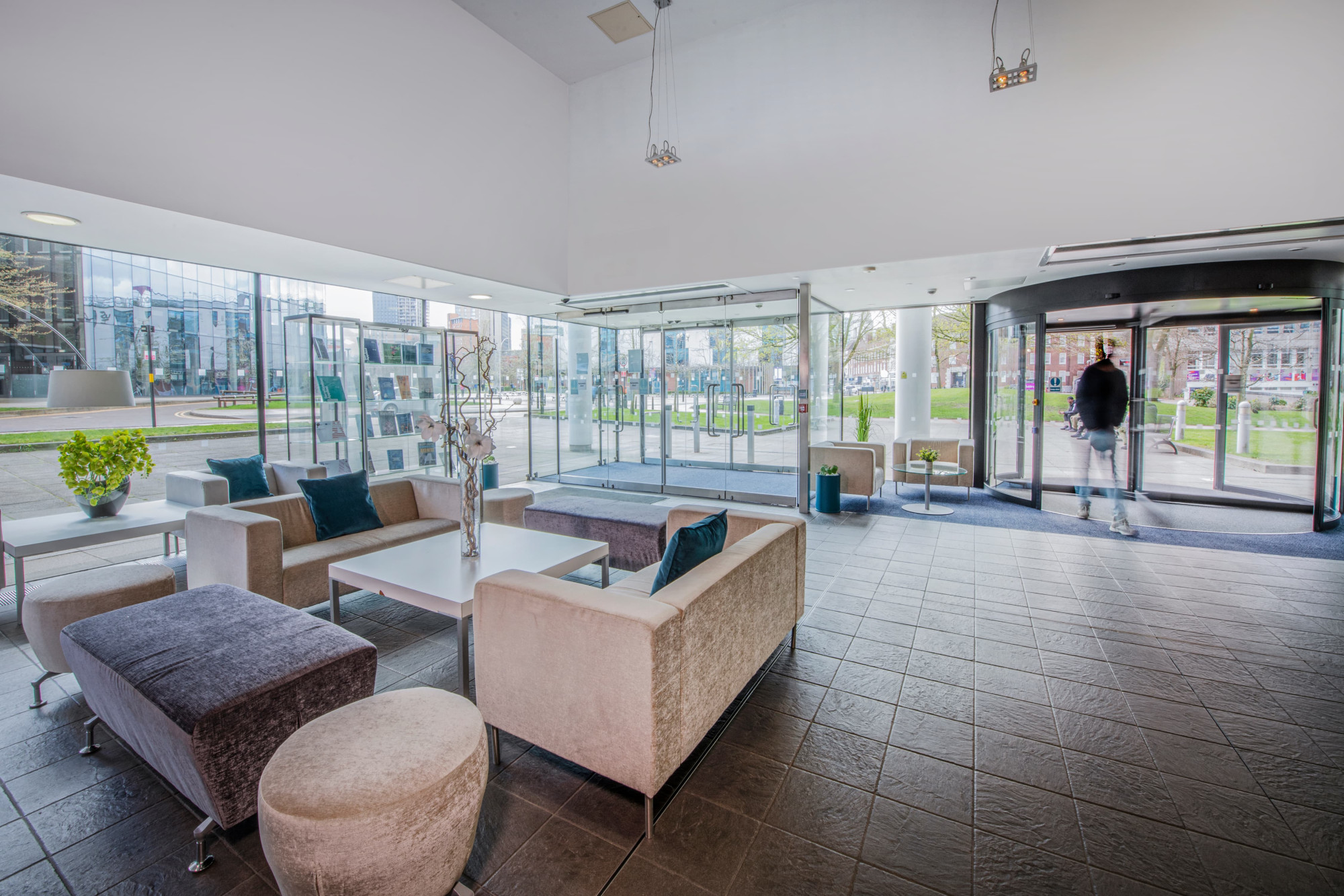Modern business center lobby with bright windows, ideal for meetings and events. - Banner