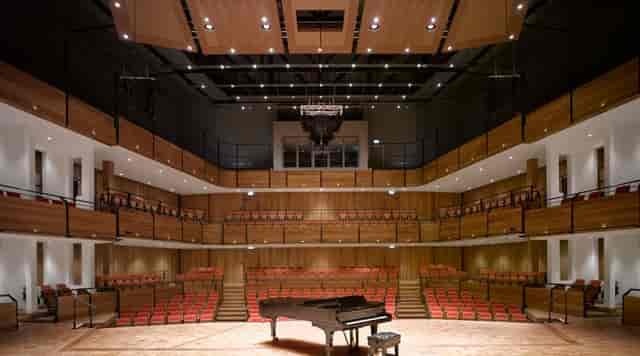 Modern auditorium with grand piano in Bramall Music Building, ideal for conferences and concerts.