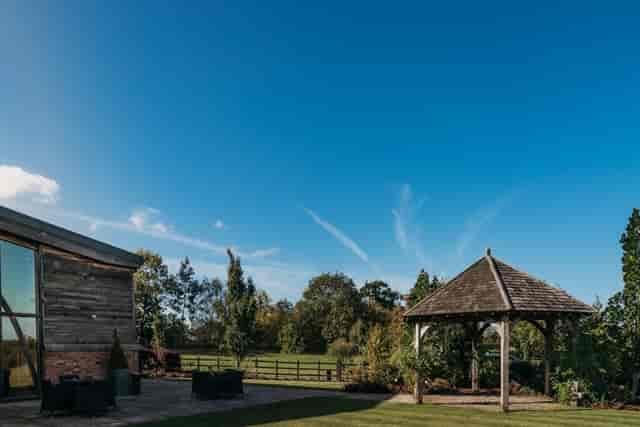 Gazebo at Mythe Barn, ideal outdoor venue for events with lush greenery and rustic charm.