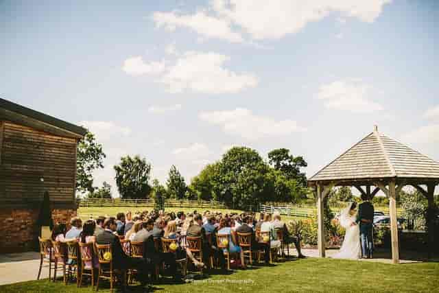 Gazebo at Mythe Barn for a picturesque outdoor wedding ceremony with lush greenery.