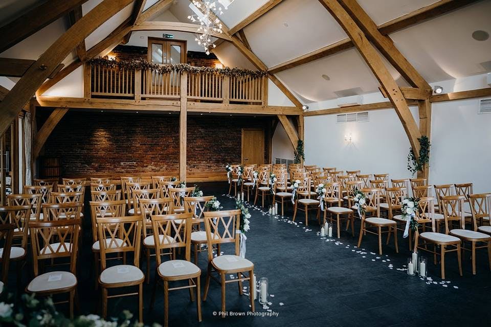 Ceremony setup in Mythe Barn with rustic beams, ideal for intimate weddings.