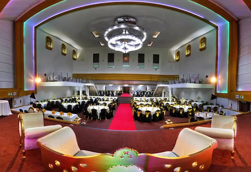 Elegant restaurant event space in Badshah Palace with black and gold decor.
