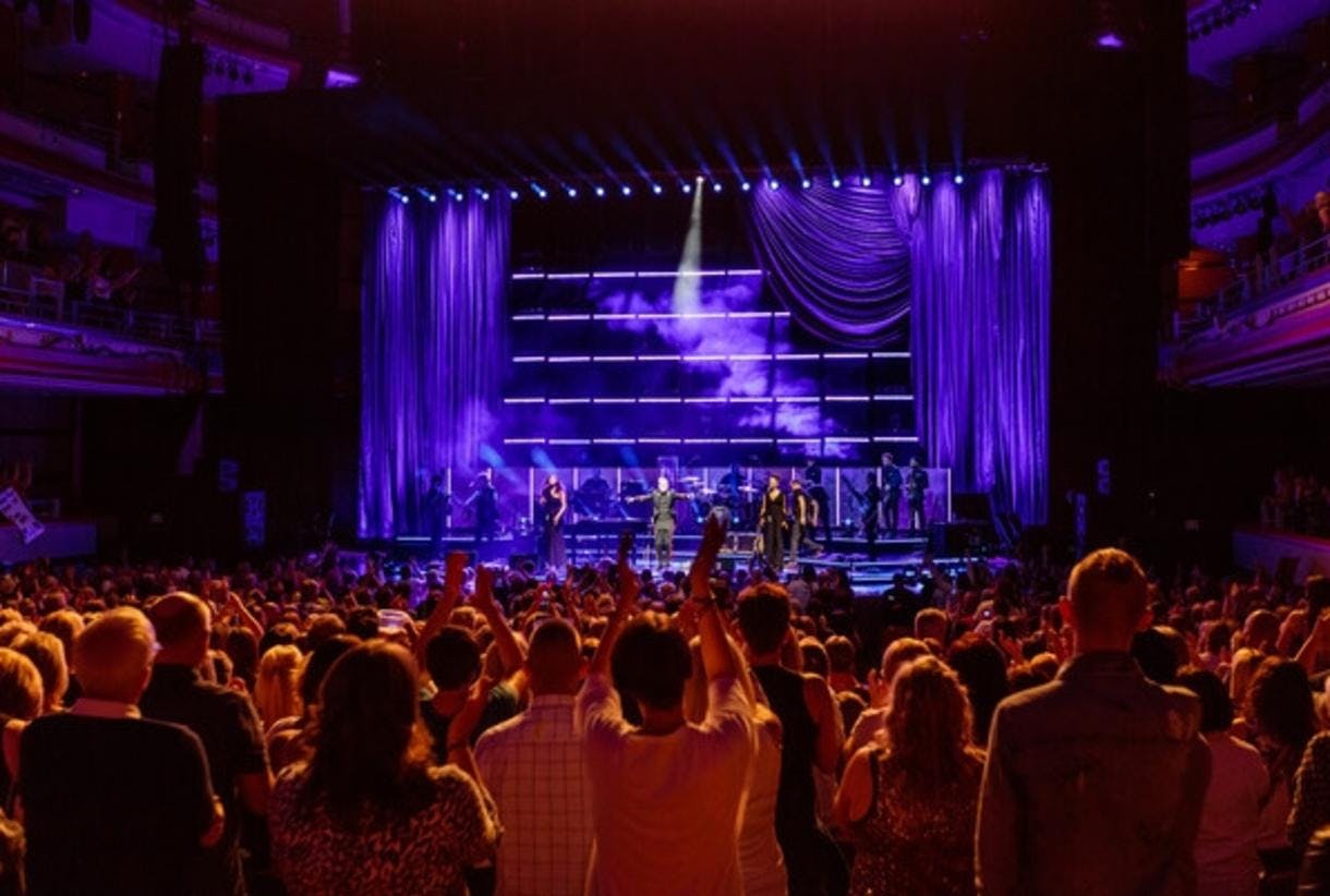 Live music venue in Birmingham with vibrant purple lighting and engaged audience.