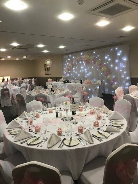 Elegant banquet hall with pink accents, perfect for weddings and celebrations.