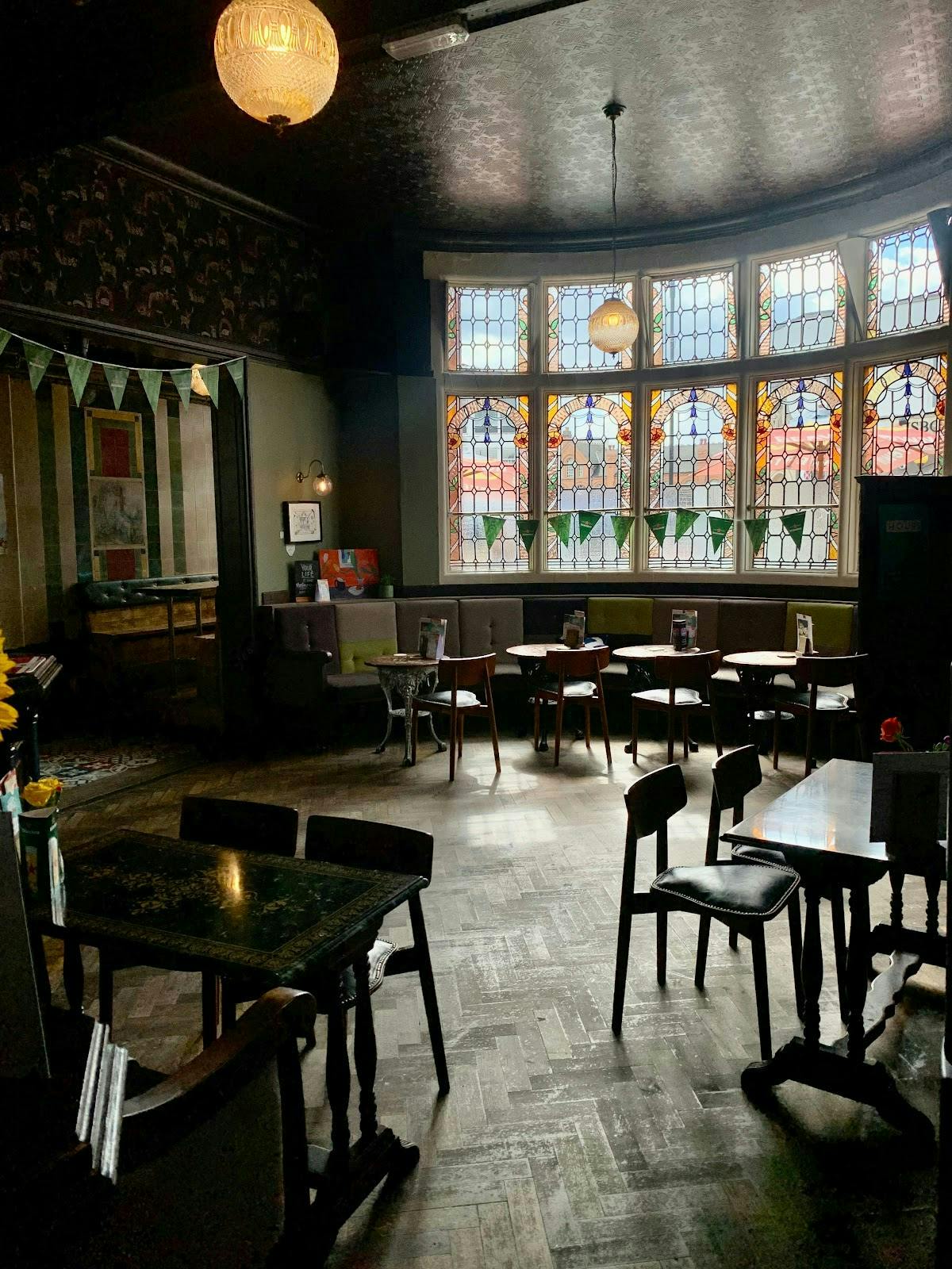 Cozy garden area at Rose Villa Tavern with stained glass, perfect for intimate events.