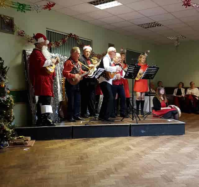 Festive musical performance at Cheswick Green Village Hall during holiday event.