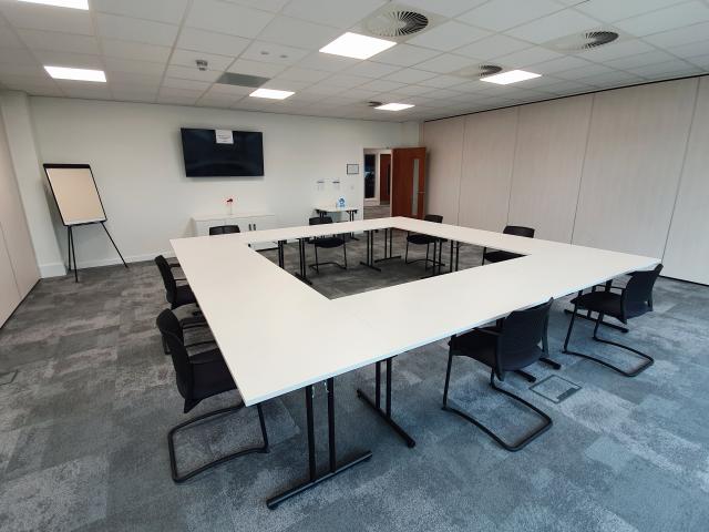 Modern training room with large table, ideal for workshops and meetings. - Banner