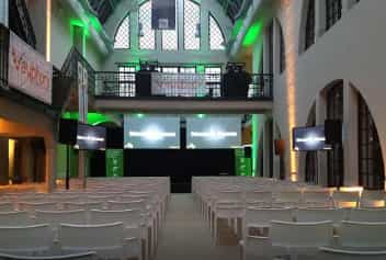 Event space with white chairs and dual screens, perfect for conferences and corporate gatherings.