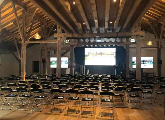 Spacious event venue with black chairs, ideal for corporate meetings and workshops.