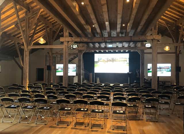 Spacious event venue with black chairs, ideal for corporate meetings and workshops.