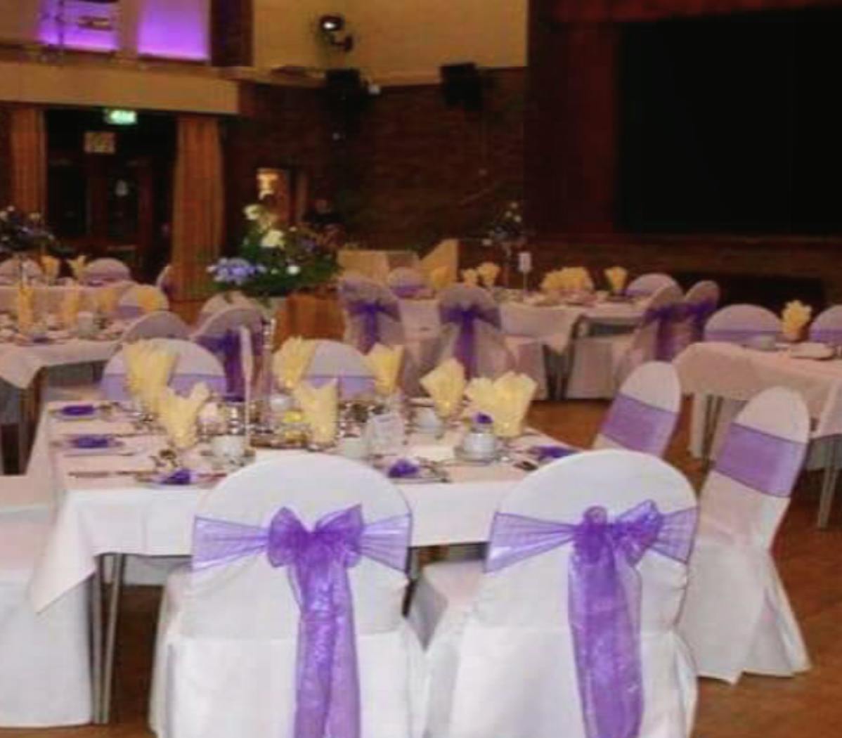 Elegant event space at The Addison Centre with white linens and purple accents for weddings.