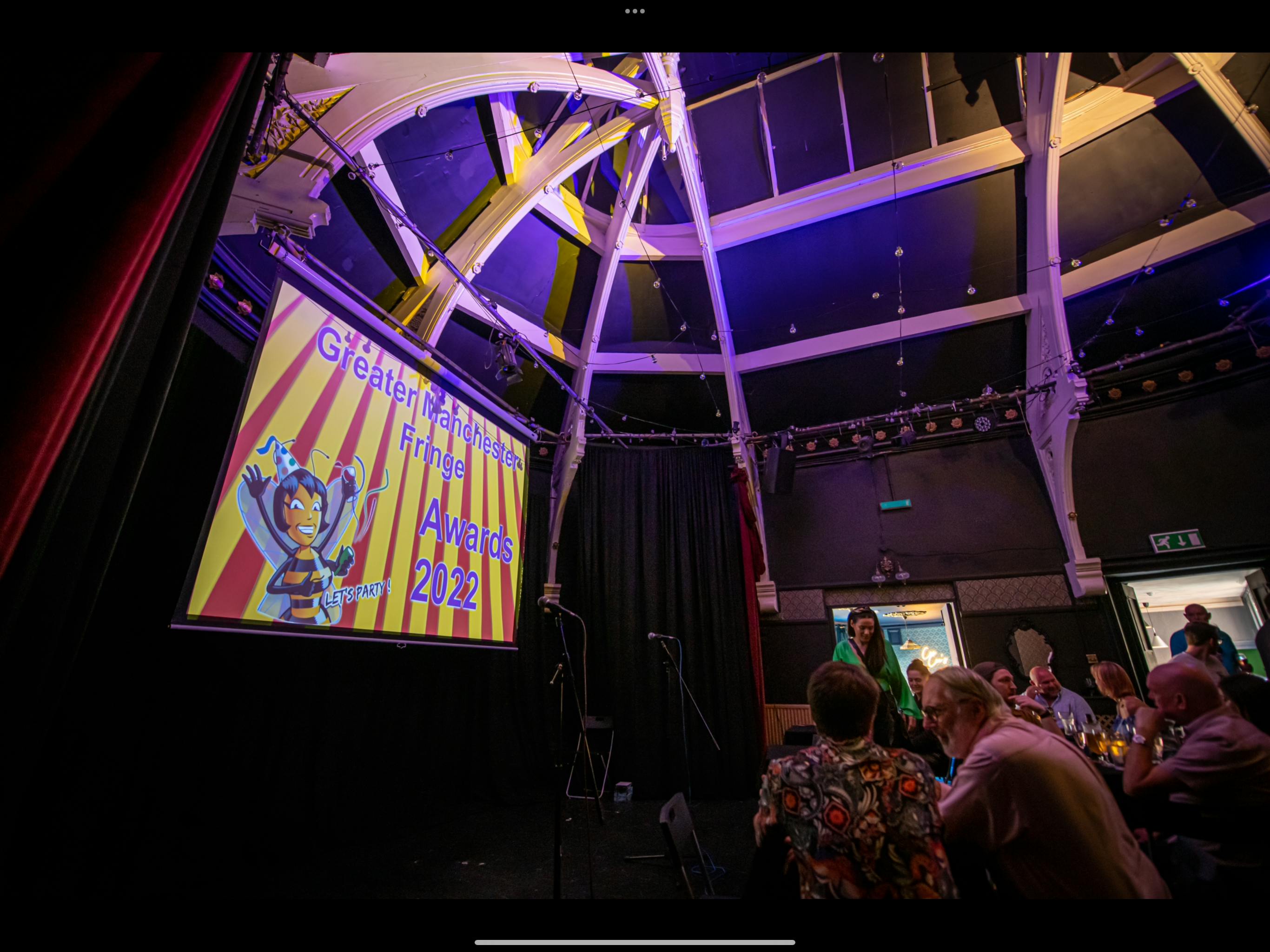Kings Arms Theatre awards ceremony with colorful backdrop and festive atmosphere.
