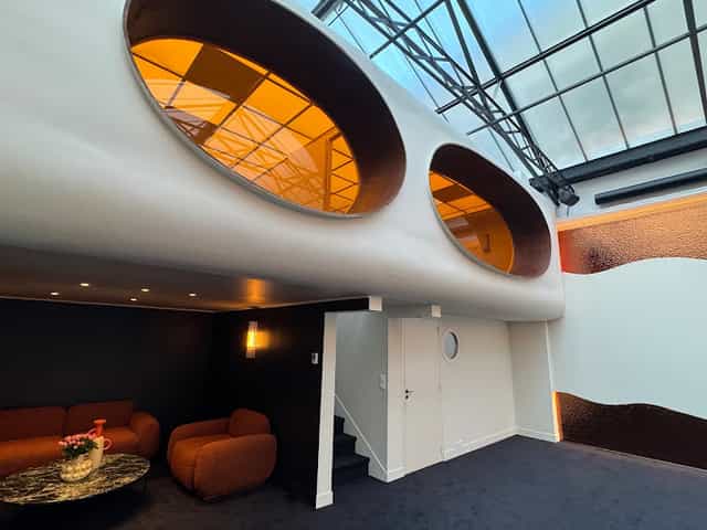 Modern event space with oval windows, ideal for meetings and upscale receptions.