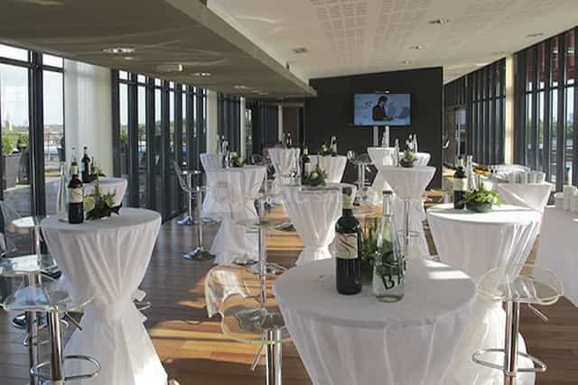 Modern VIP meeting room with high-top tables for networking events and receptions.