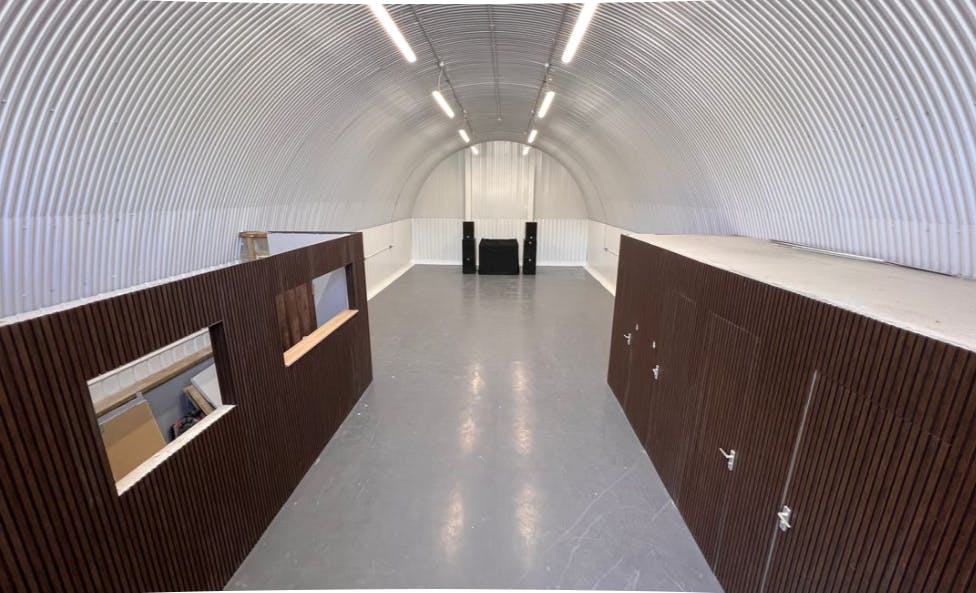 Spacious industrial event space with high ceilings for workshops and exhibitions.