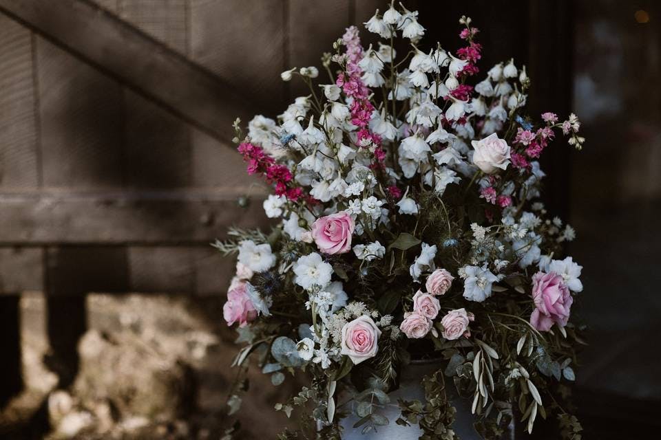 Floral centerpiece with pink roses for elegant event decor at Barn Door Events.