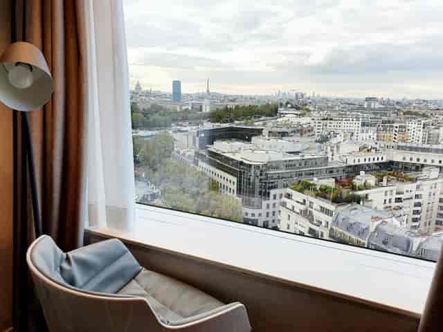 Hotel room with cityscape view, ideal for meetings and events in Paris.
