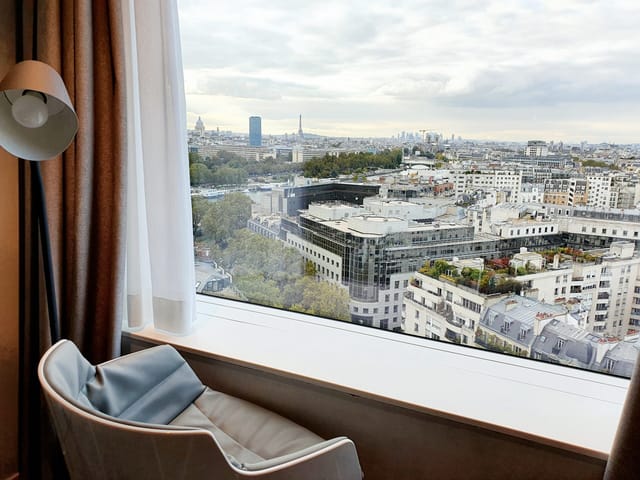 Hotel room with cityscape view, ideal for meetings and events in Paris.