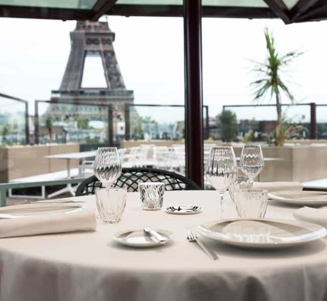 Elegant dining table at Les Ombres restaurant with Eiffel Tower view for corporate events.