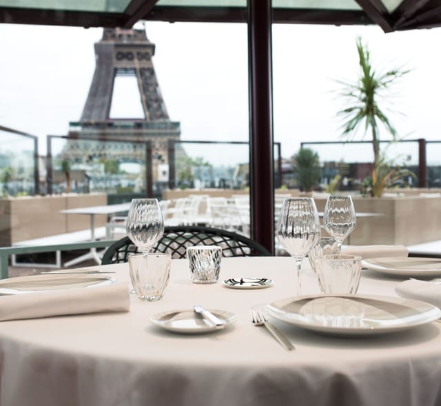 Elegant dining table at Les Ombres restaurant with Eiffel Tower view for corporate events.