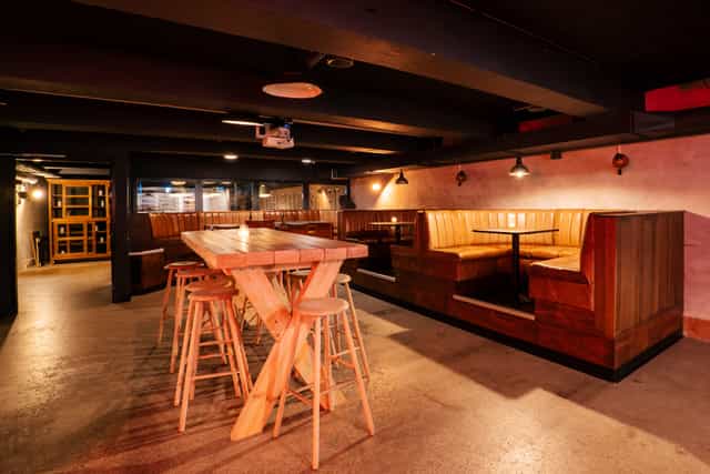 Versatile event space with wooden tables, ideal for networking and casual meetings.