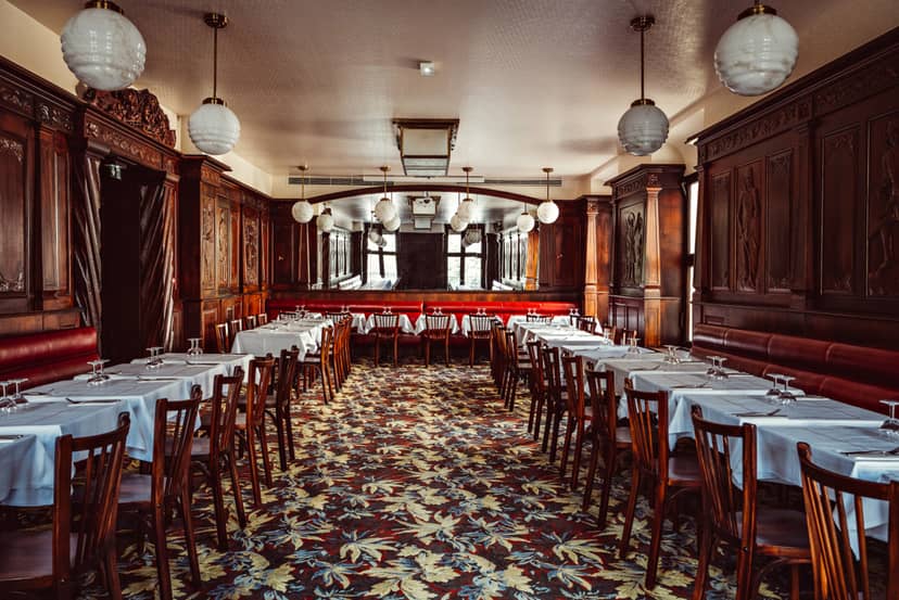 Elegant dining space in Bouillon République, ideal for events with white linens and vintage decor.