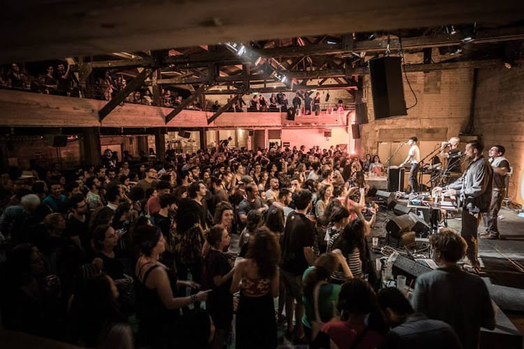 Vibrant live music event at LA LOGE VIP, featuring a rustic venue and engaged attendees.