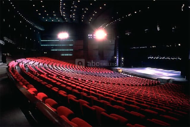 Spacious auditorium with tiered red seating for conferences at Palais des Congrès de Paris.