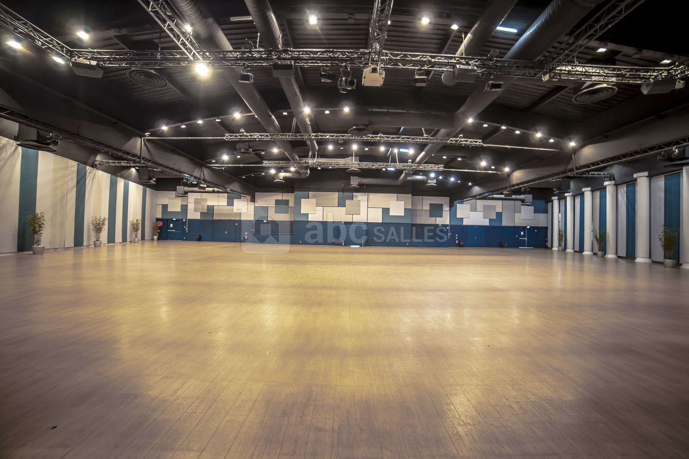 Spacious event venue Salle Capella with polished wooden floor, ideal for conferences and banquets.