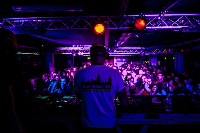 DJ performing at Le Club, La Bellevilloise, vibrant live event atmosphere.